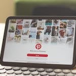 A tablet on a wooden desk showcasing the Pinterest login screen, emphasizing digital connectivity.